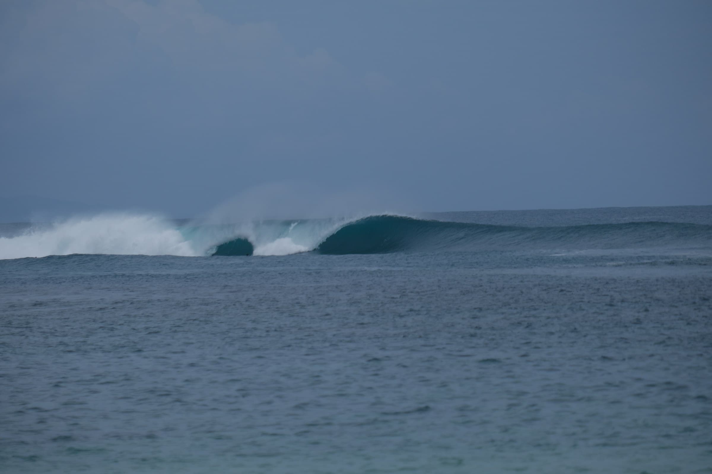 An empty wave peeling down the reef with nobody out