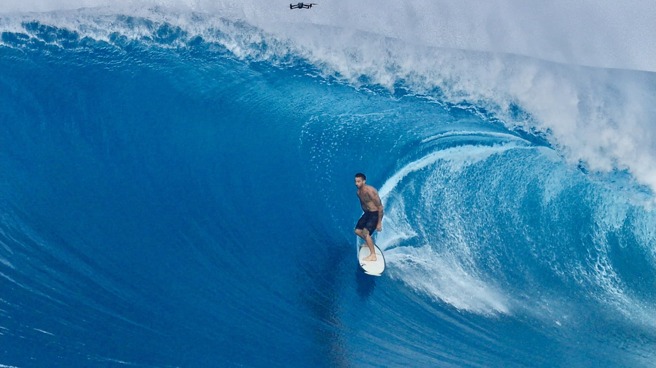 A surfer high on the face as the lip throws over