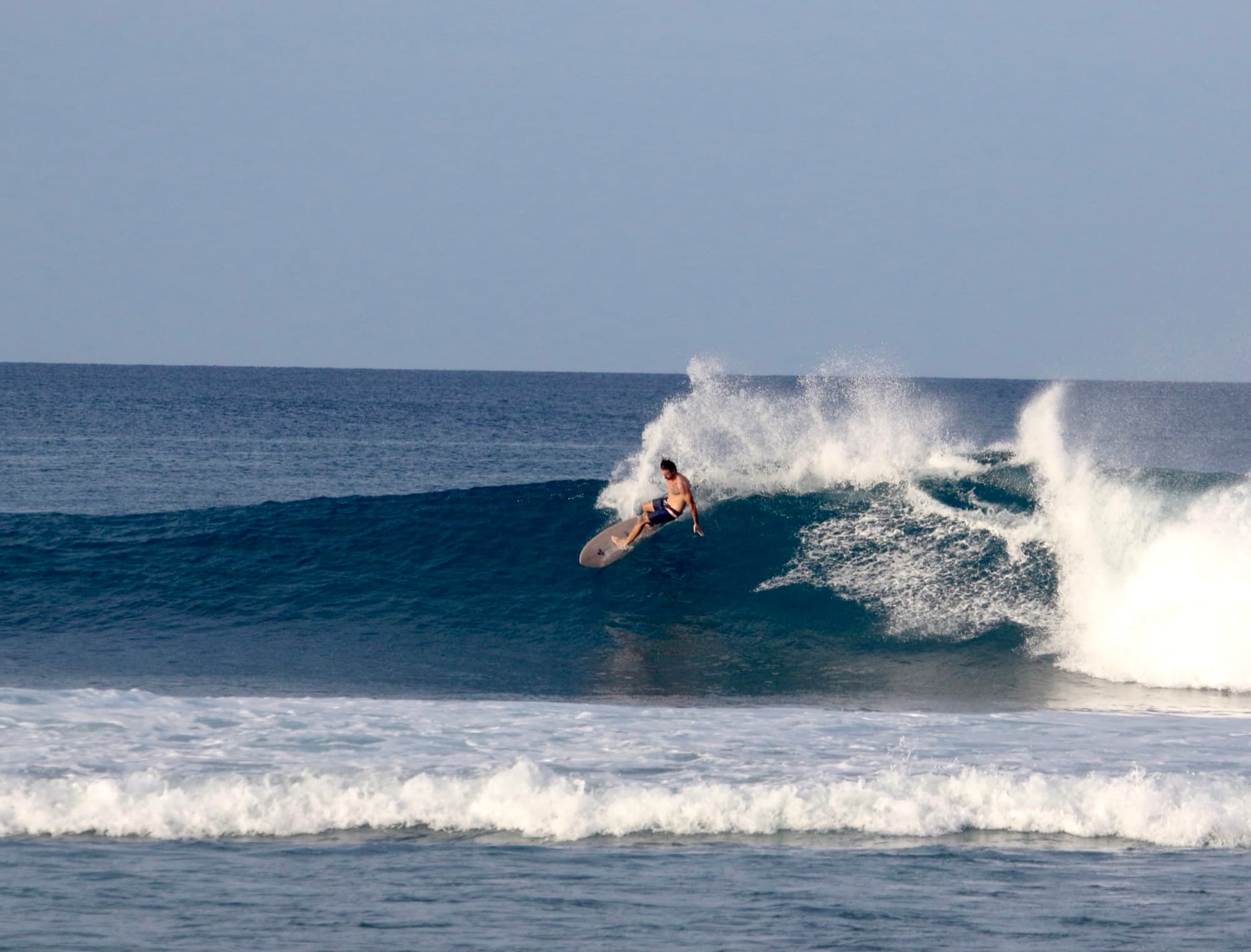A surfer turning off the top on a clean wave