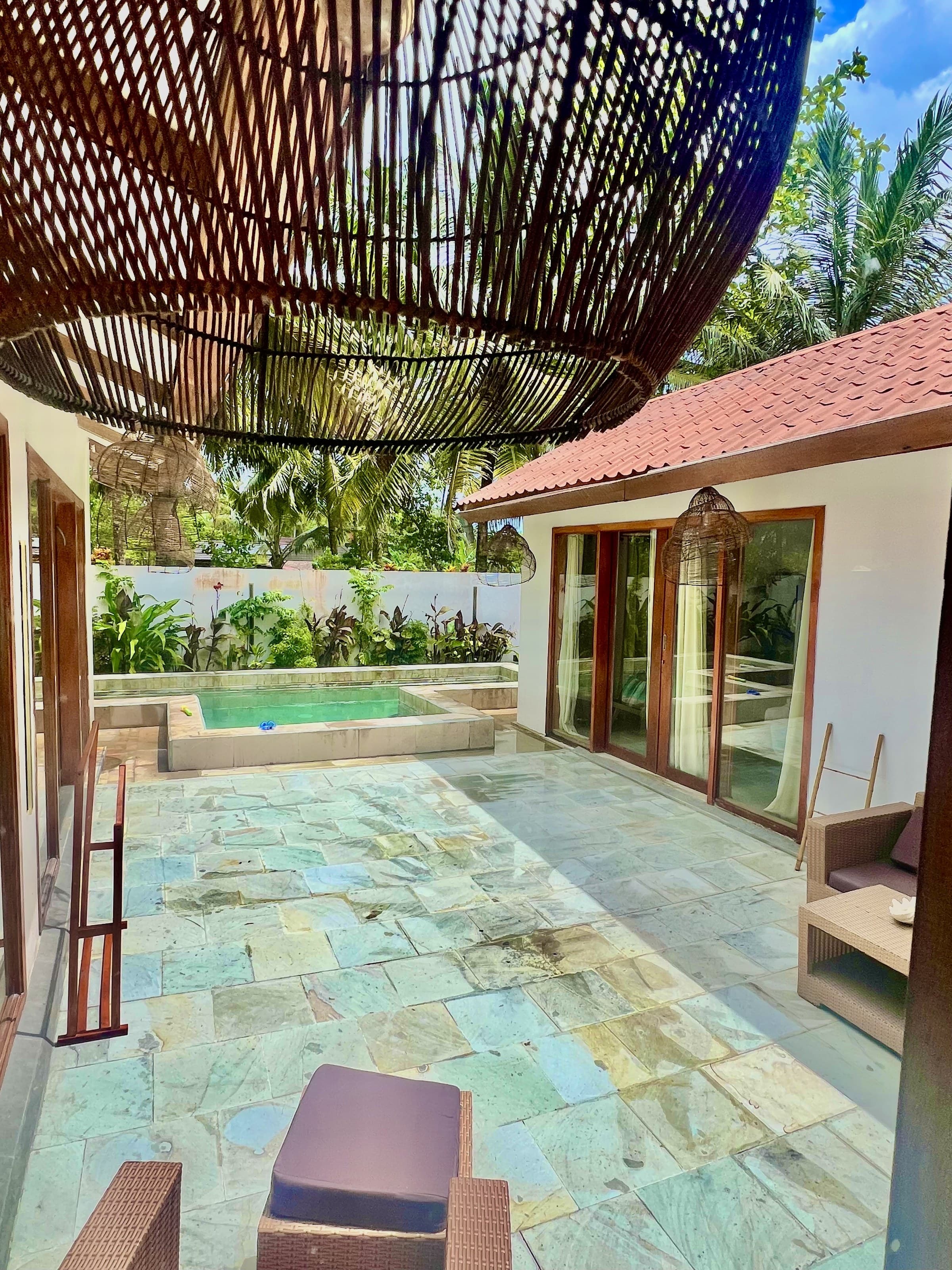 The pool terrace under the shade of the villa